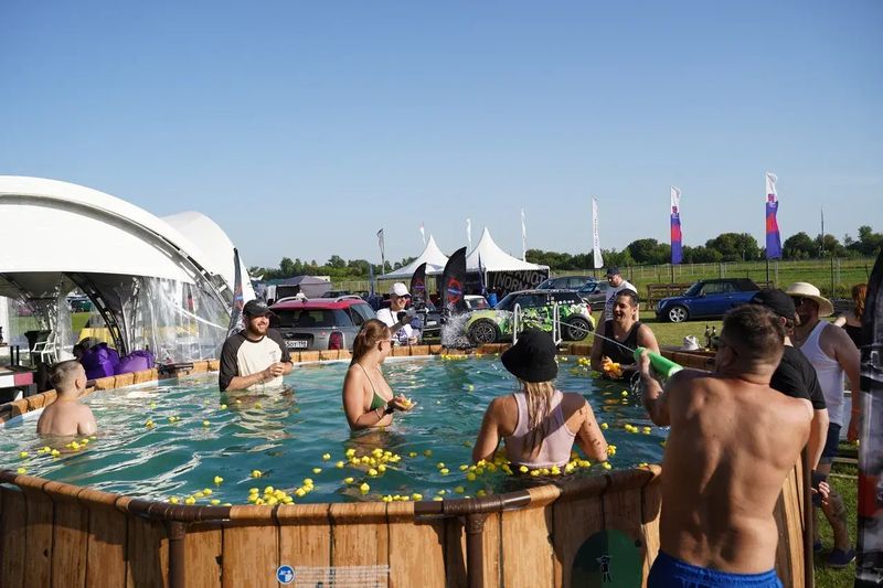 Участники фестиваля в деревянной купели под открытым небом — Not Normal Camp 2025