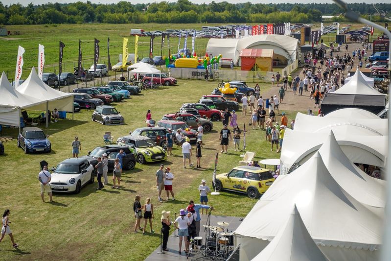 Участники кемпа среди разноцветных MINI в солнечный день — Not Normal Camp 2025